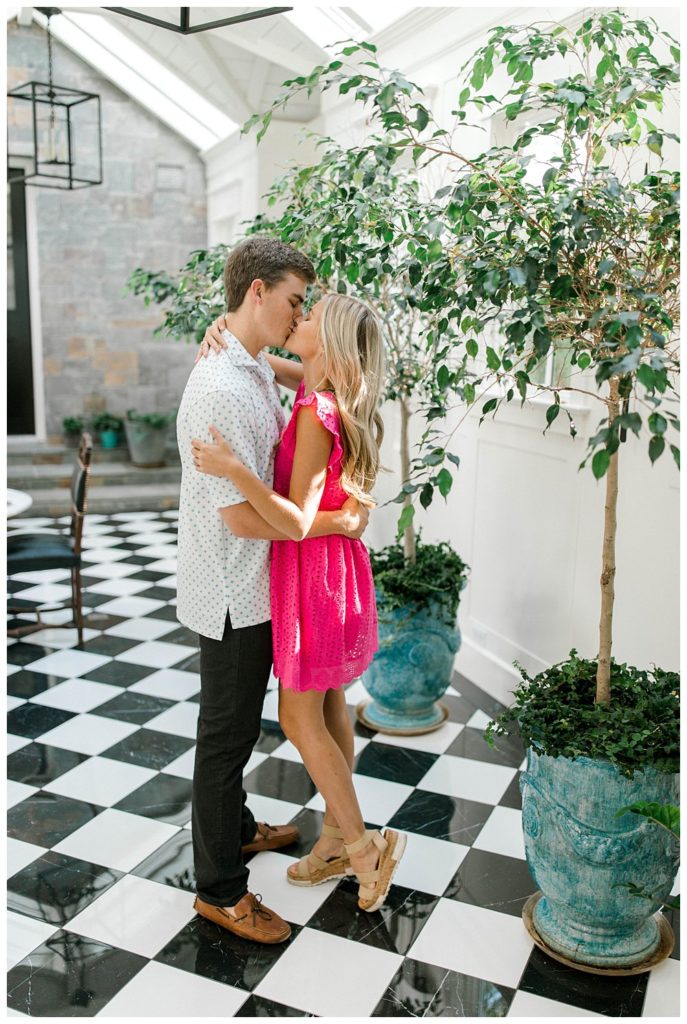 Couple kissing in greenhouse in Dallas estate engagement