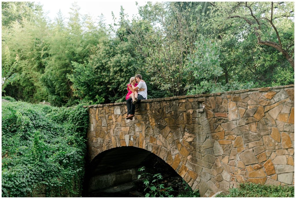 Guy and girl cuddling on stone bridge