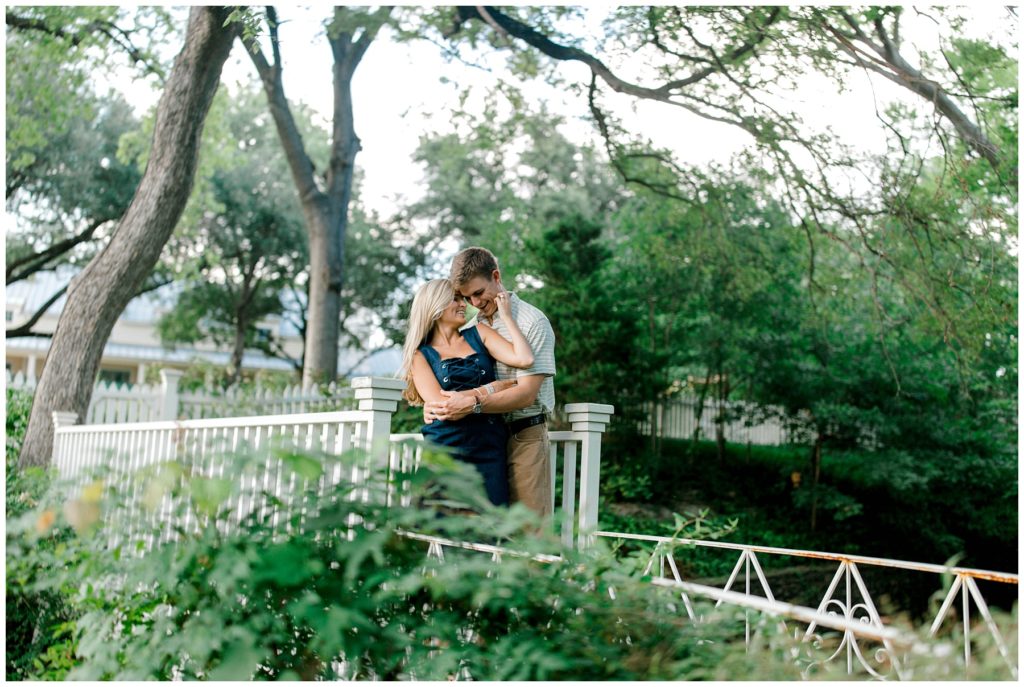 Guy hugging girl from behind holding her hands in Dallas engagement