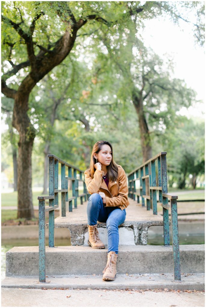 Girl sitting on cement steps under tree in Fort Worth Trinity Park senior session