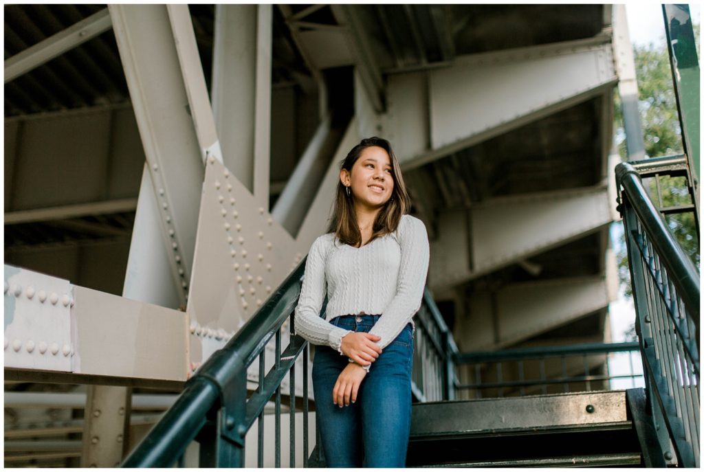 Girl standing on steps under bridge