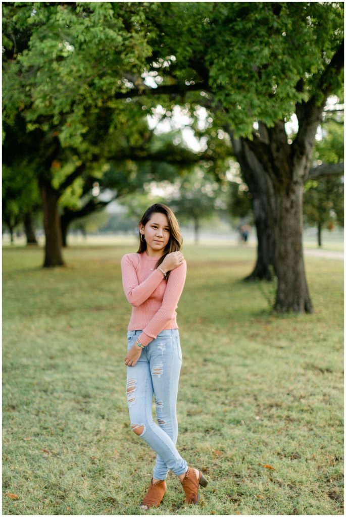 Girl standing in park under tree in Fort Worth Trinity Park senior session