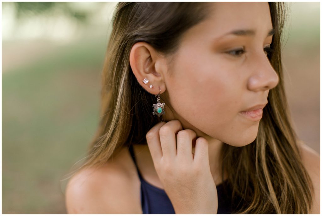 Close up of girl with triple pierced ears and turtle earrings