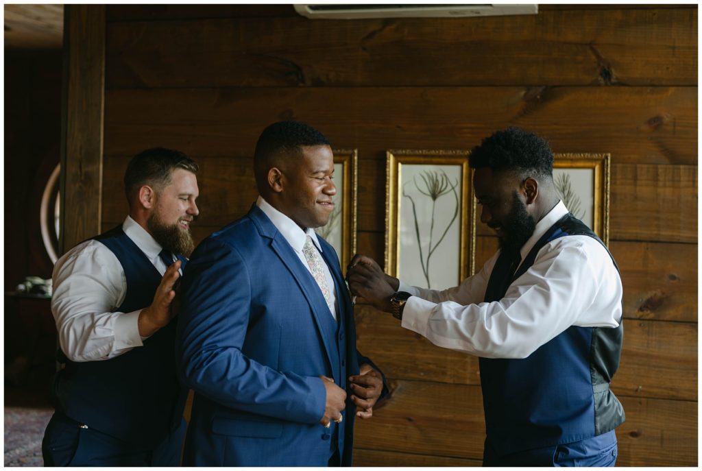 Groomsmen helping groom get ready