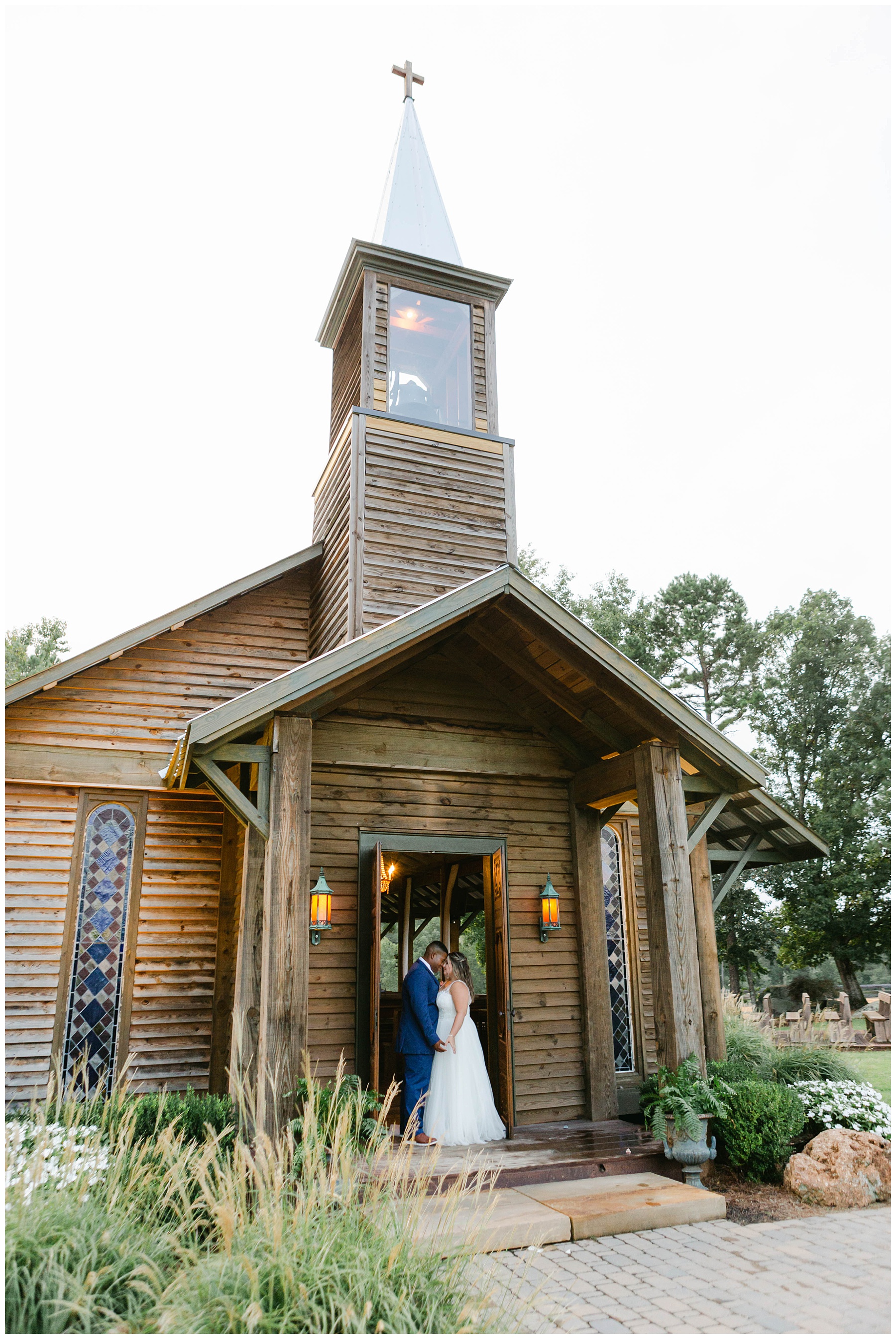 Bride and groom nuzzling in doorway of The Kelly chapel at Pine Knoll Farms