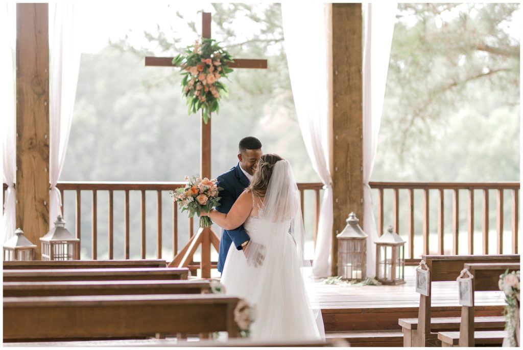 Bride and groom embracing during first look at Pine Knoll Farms The Kelly Chapel
