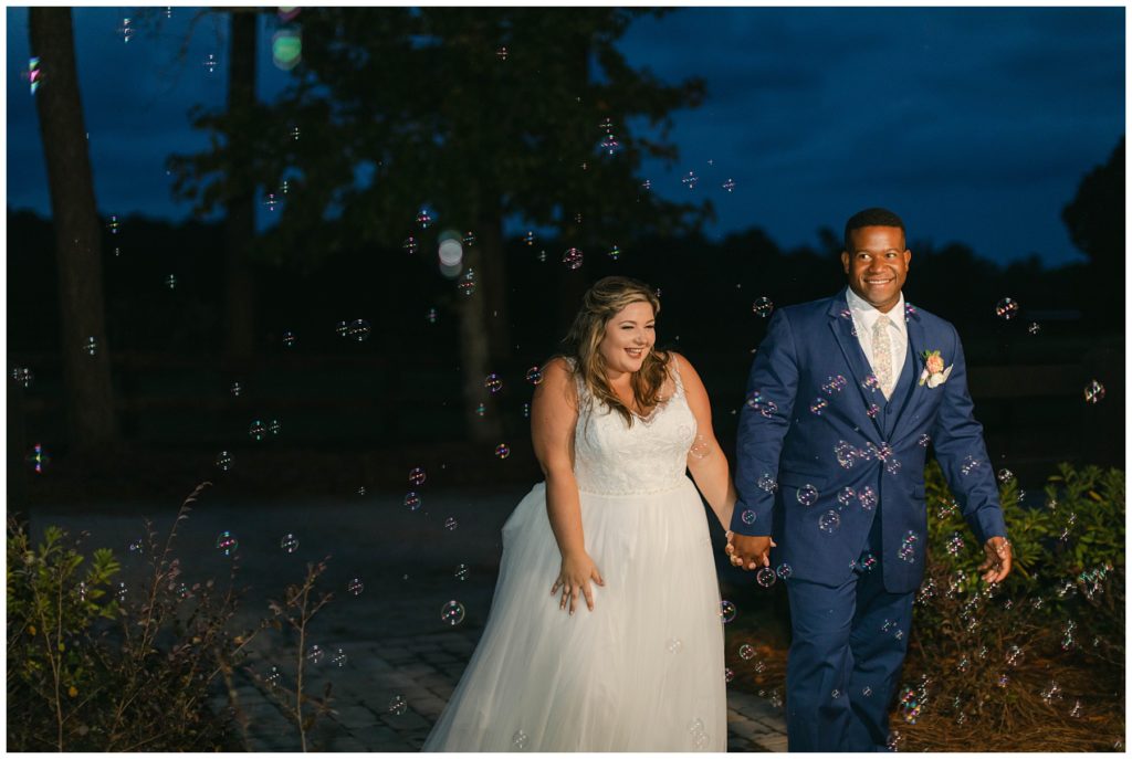 Bride and groom walking through bubbles for grand entrance to reception