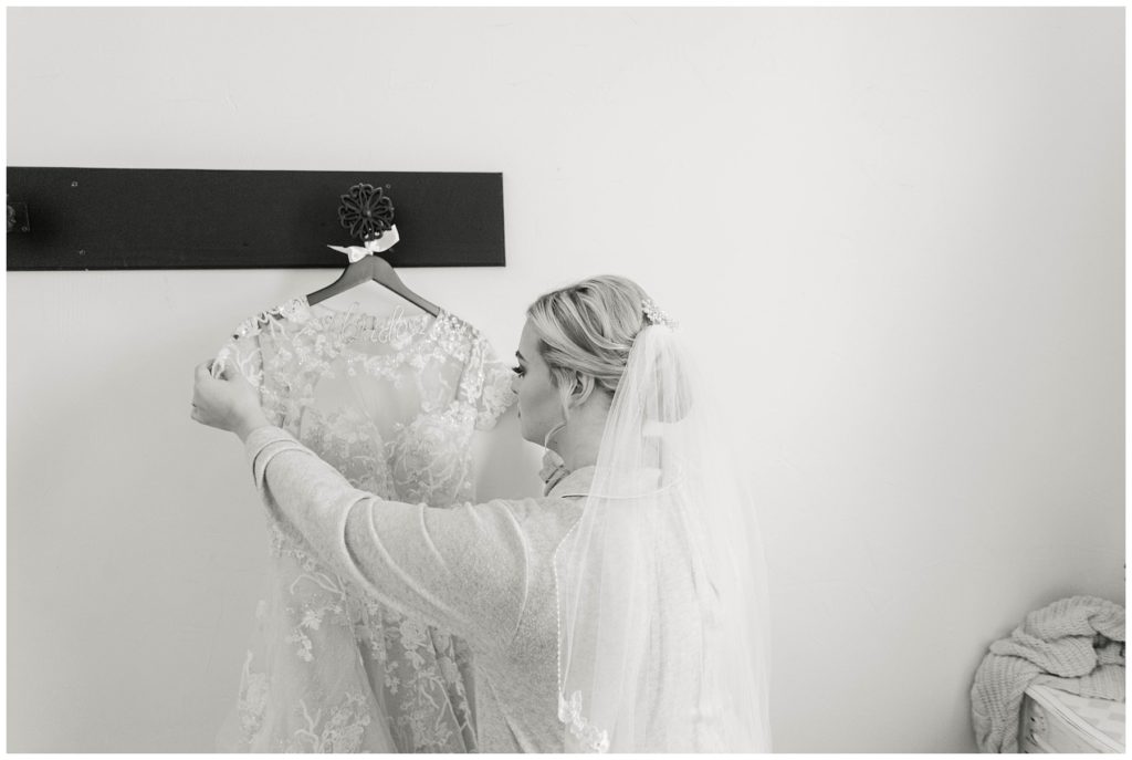 Bridesmaids looking at bride's wedding gown train