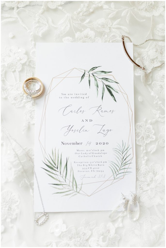 white and green wedding invitation with wedding jewlery