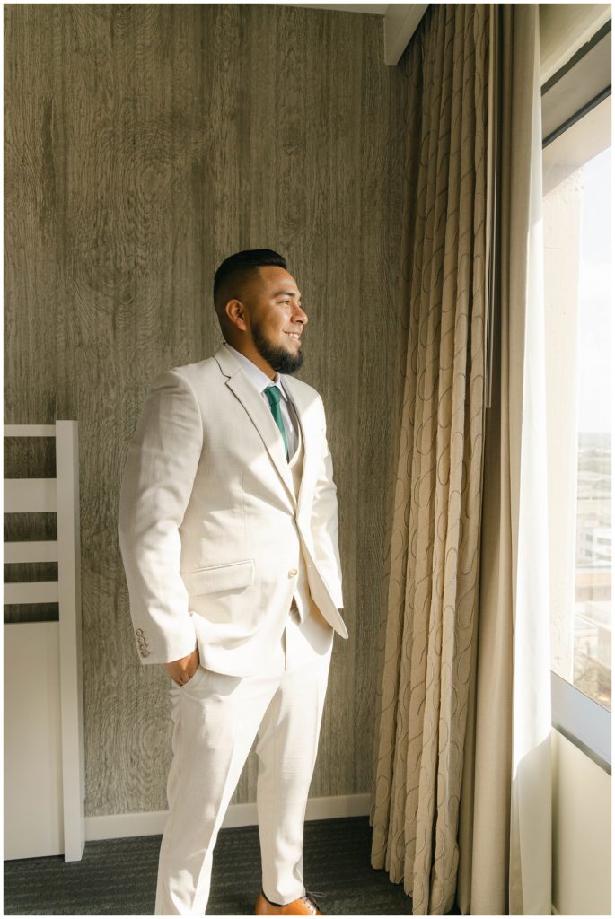 Groom standing by window