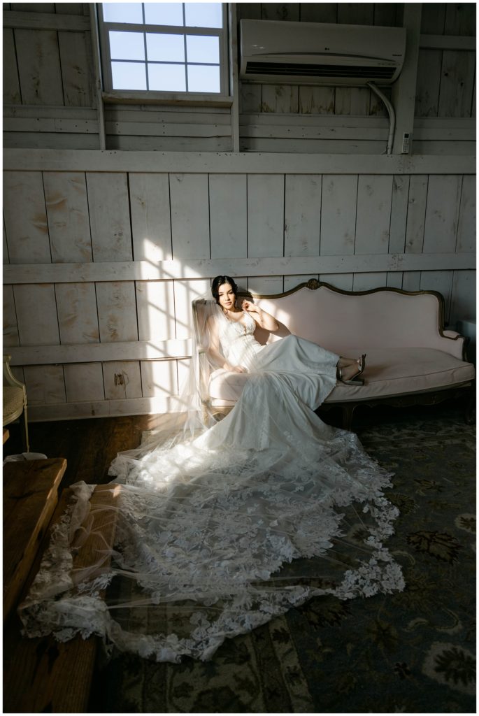 Bride laying on pink couch in Big White Barn wedding