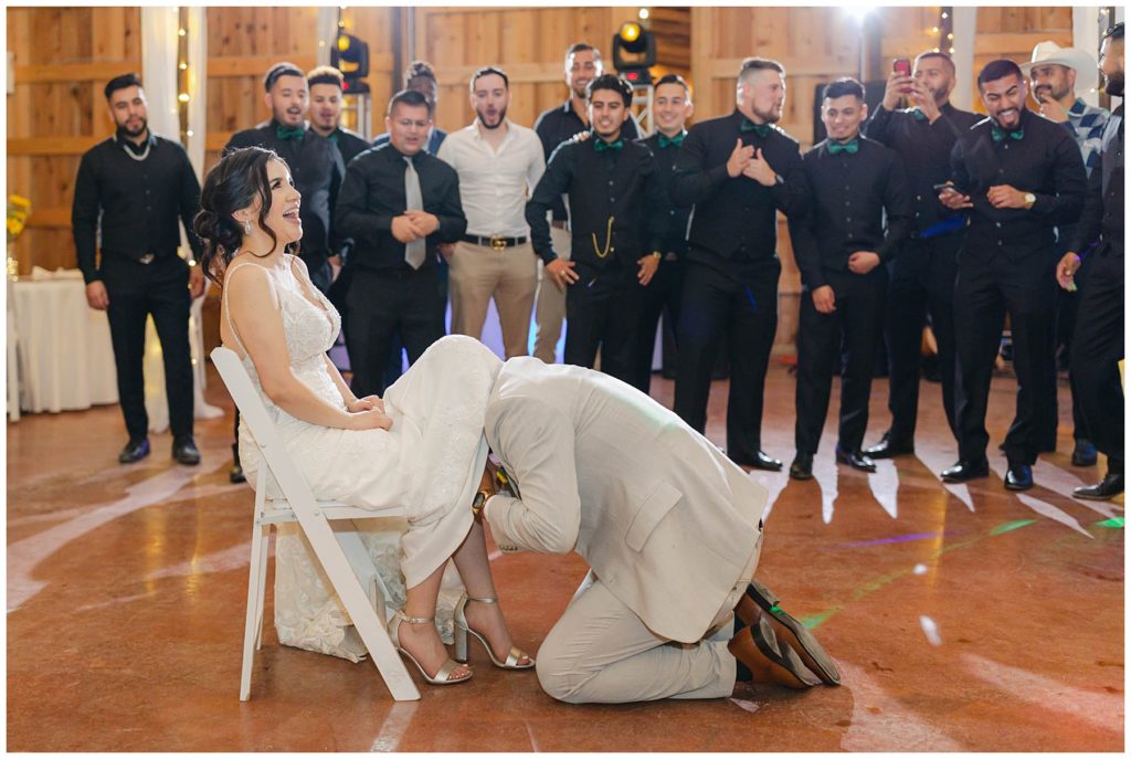 Groom garter toss at The Big White Barn wedding