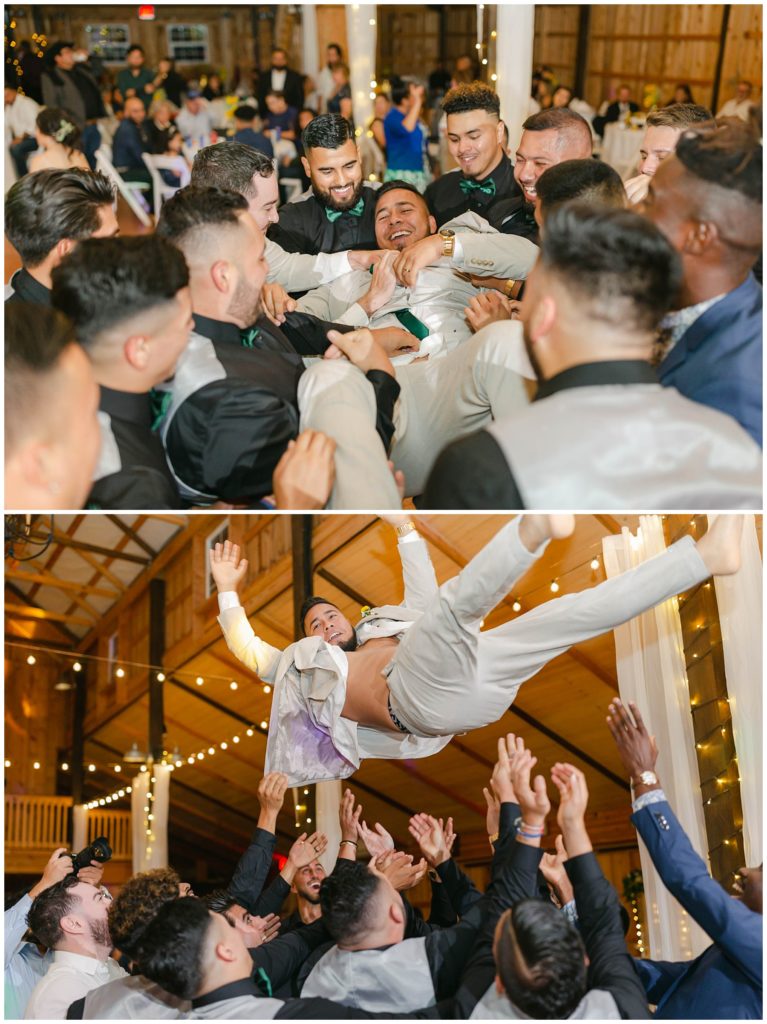 Groom being tossed in air at Big White Barn wedding reception