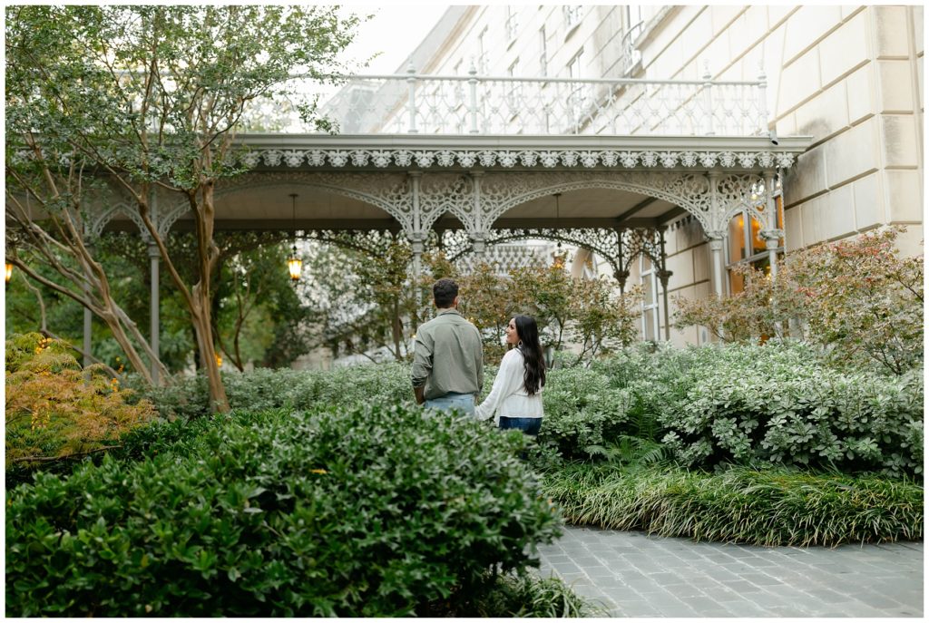 Couple walking through garden at Hotel Crescent Court engagement