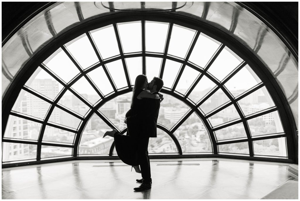 BW silhouette couple kissing in front of window at Hotel Crescent Court engagement