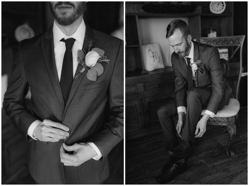 BW groom putting on shoes and buttoning suit jacket