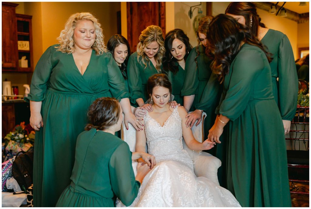 Bridesmaids praying over bride