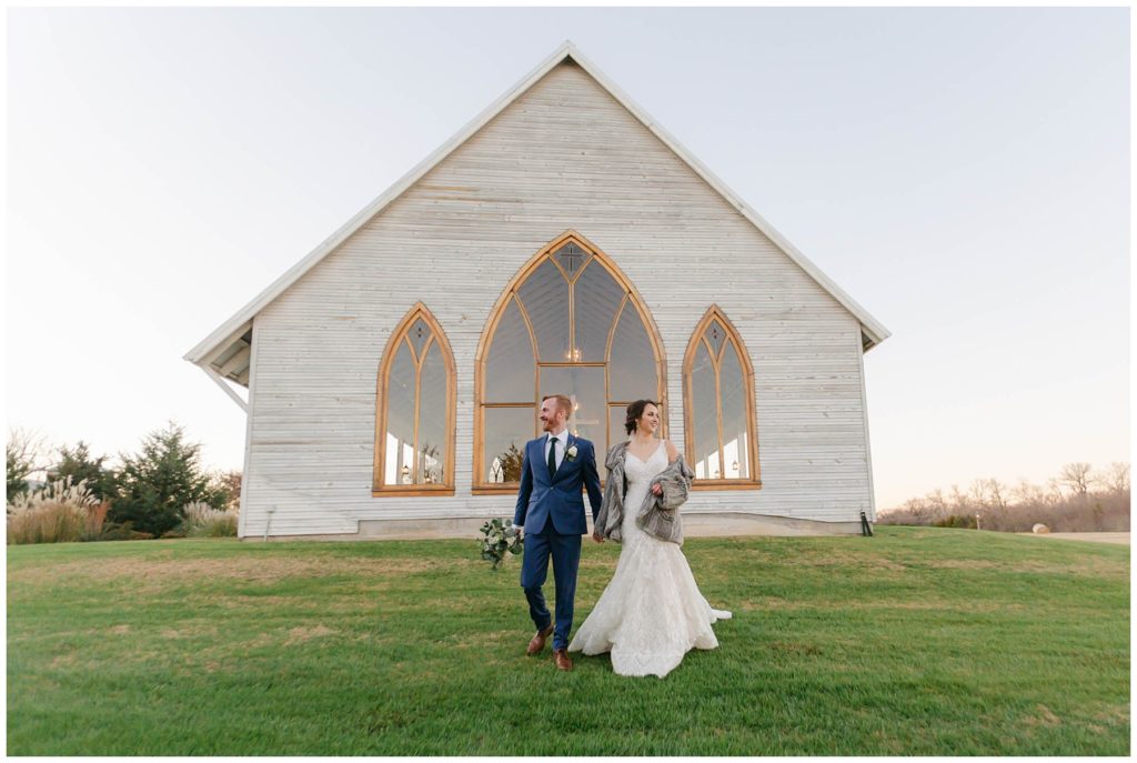 Bride and groom walking outside of The Brooks at Weatherford wedding chapel