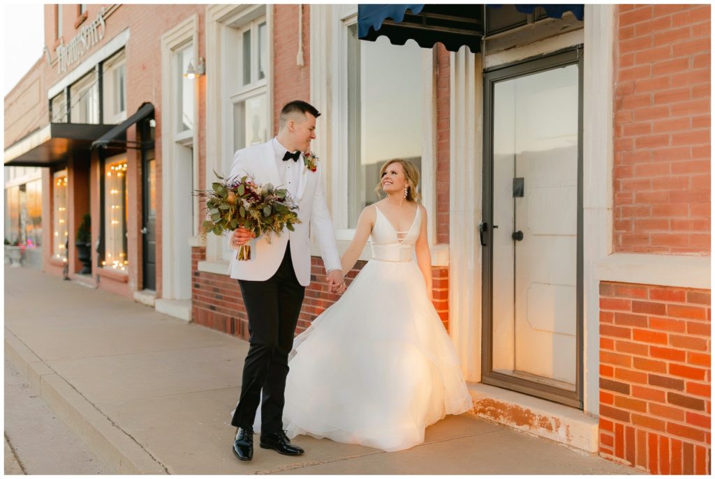 Bride and groom walking down town square Texas Hugos on the Square wedding