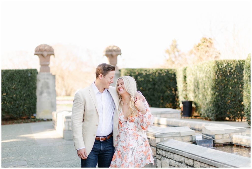 Engaged couple waking through Dallas arboretum gardens