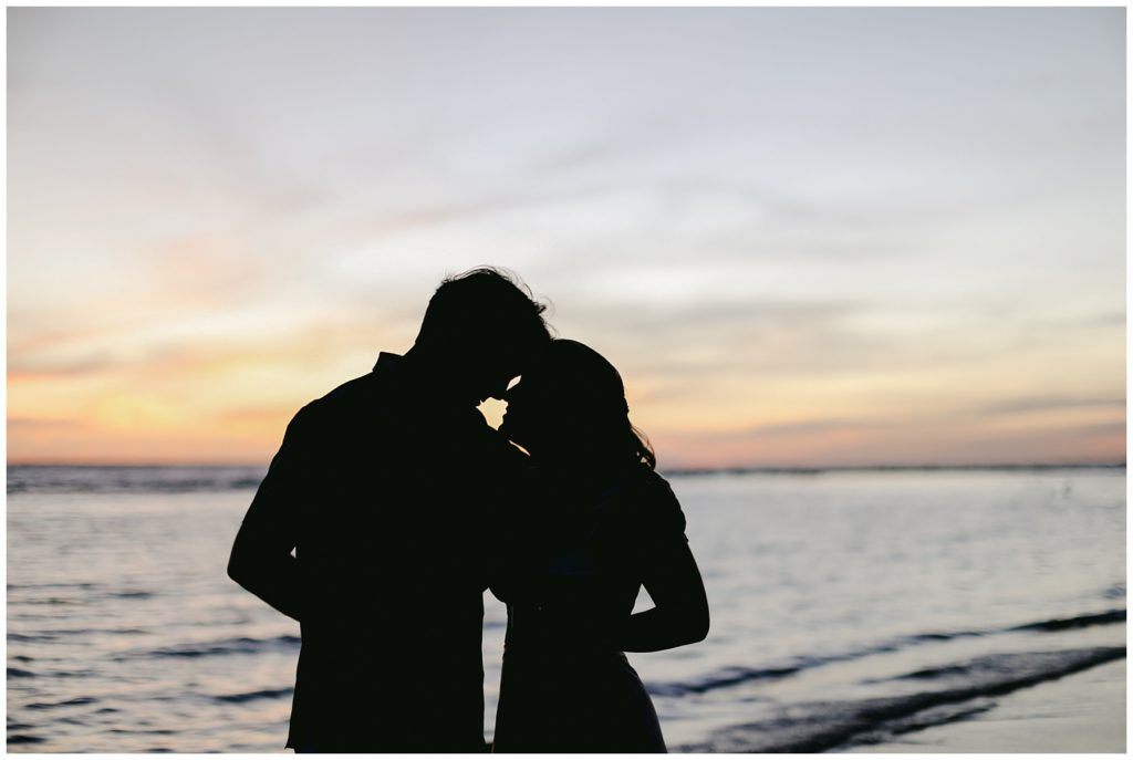 silhouette of couple nuzzling on beach