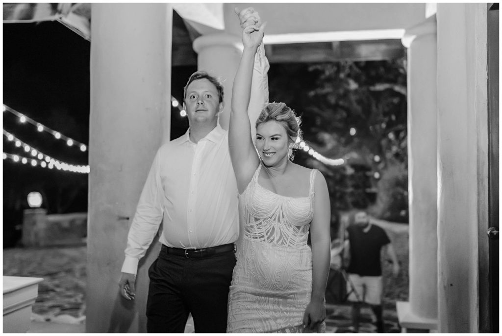 BW bride and groom walking into reception