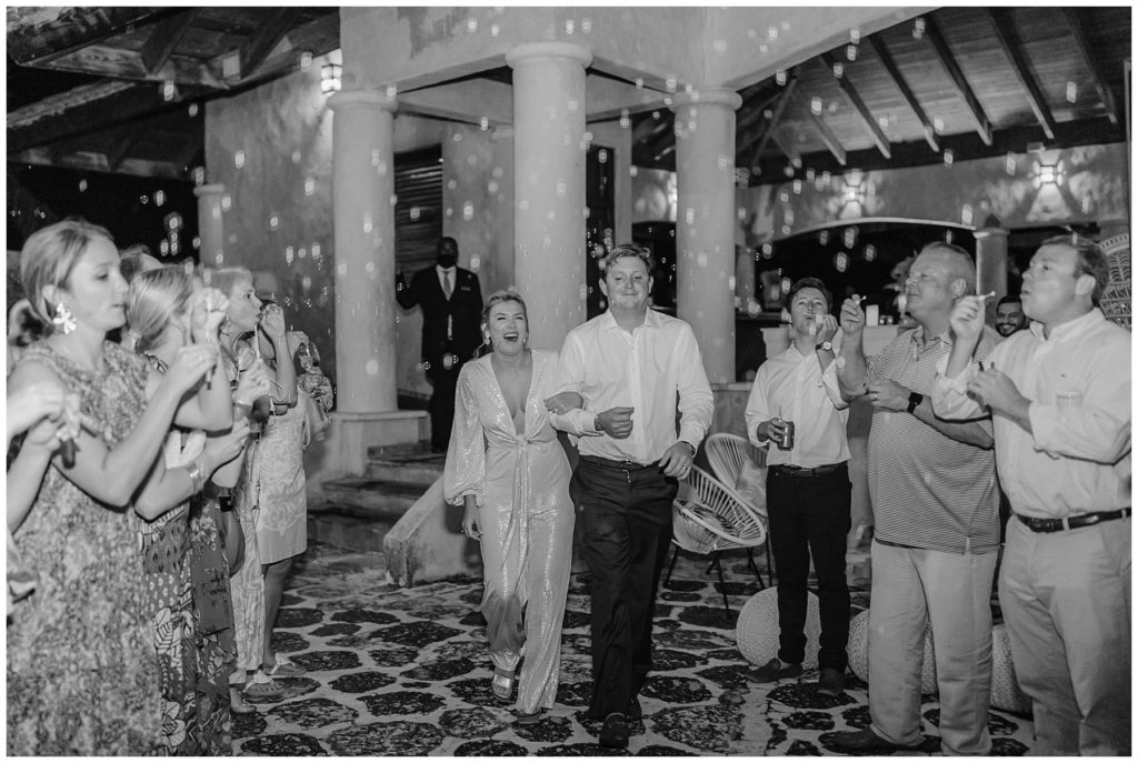 Couple walking through bubbles for wedding grand exit at Dye Force Terrance Dominican Republic Wedding