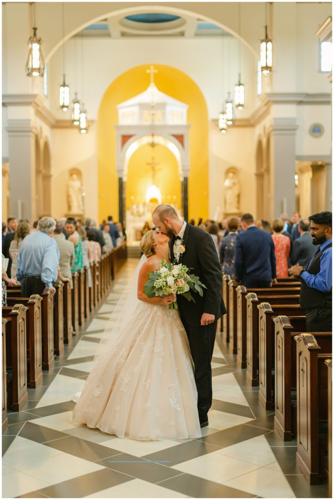 bride and groom kissing in catholic wedding