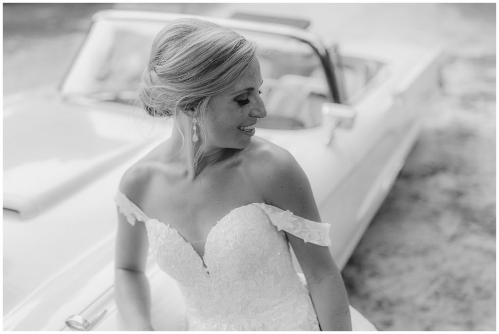 bride leaning against vintage car South Carolina Catholic wedding