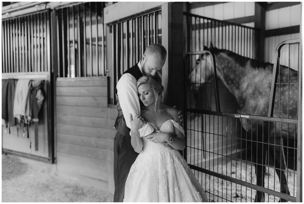 bride and groom hugging in horse stable South Carolina outdoor wedding