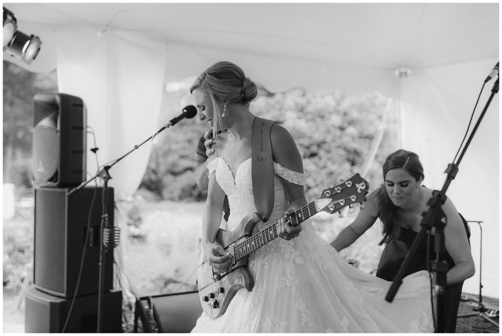 bride rocking out on stage playing guitar in South Carolina Catholic wedding