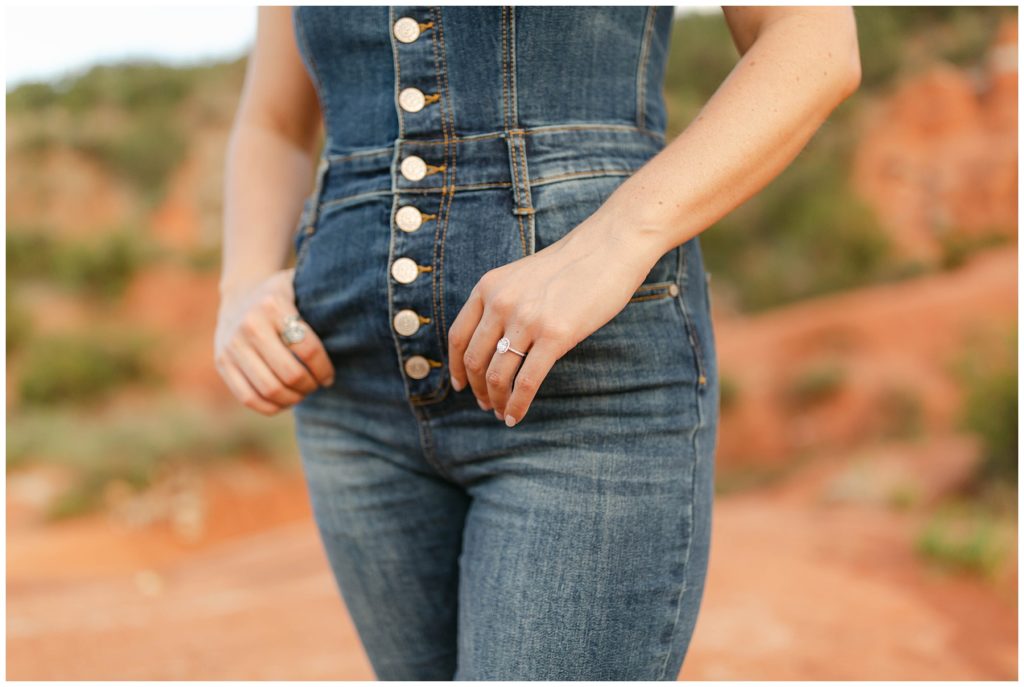 girl with hands half in pocket showing engagement ring