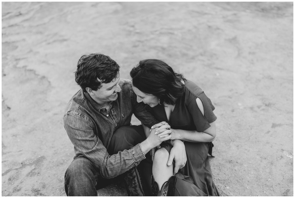 Couple cuddling and laughing in Palo Duro Canyon Texas engagement