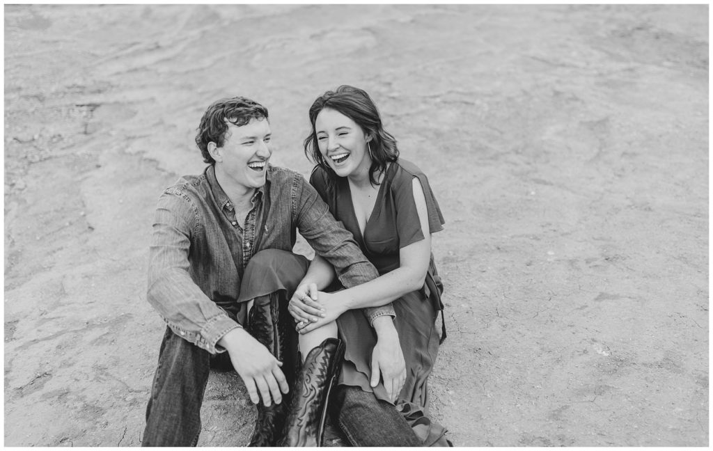 Couple cuddling and laughing in Palo Duro Canyon Texas engagement