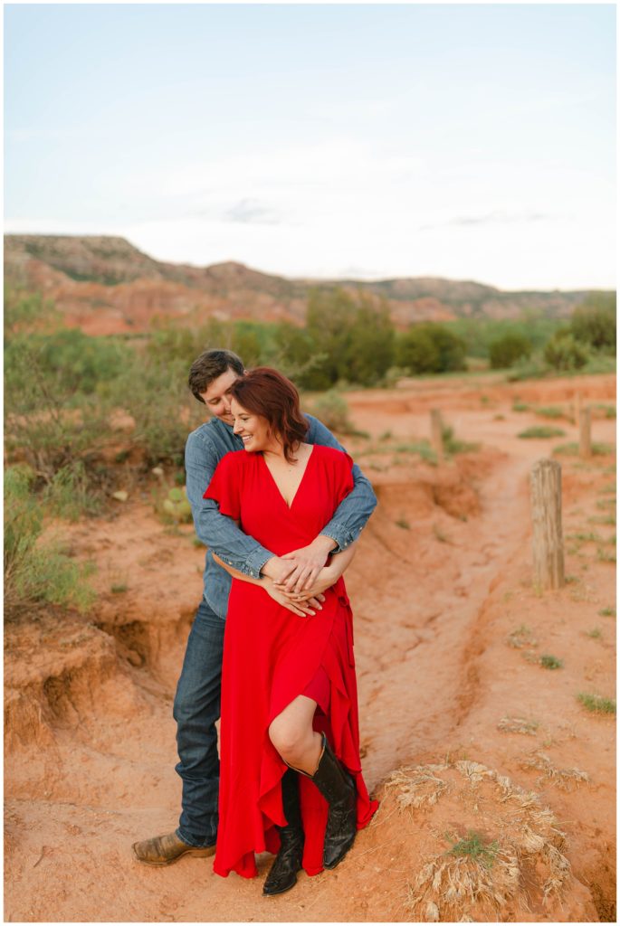 Guy hugging girl from behind in Palo Duro Canyon Texas engagement