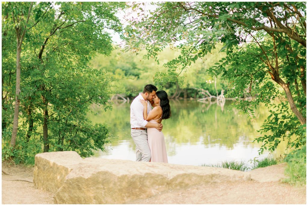 Couple kissing in the rain in Arbor Hills Nature Preserve Engagement Couple kissing by lake