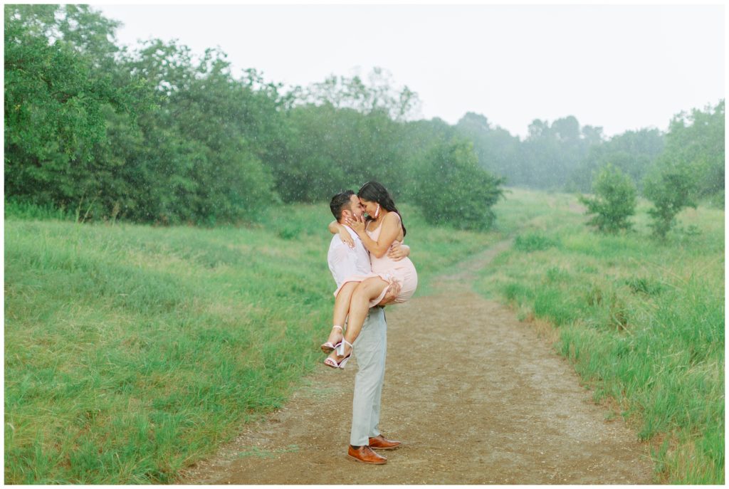 Guy holding girl kissing in rain Couple kissing in the rain in Arbor Hills Nature Preserve Engagement