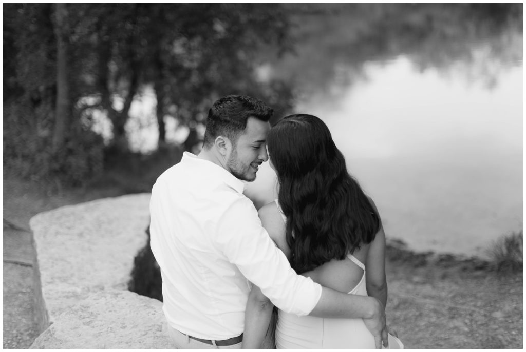 bw couple kissing on rock by lake