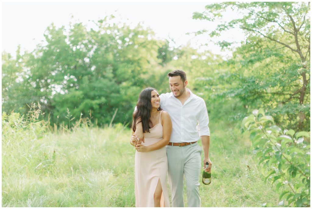 Couple walking through meadow in rain