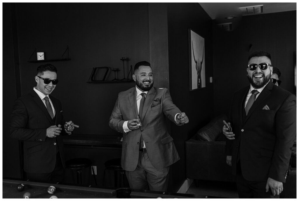 Groom and groomsmen having shots and cigars