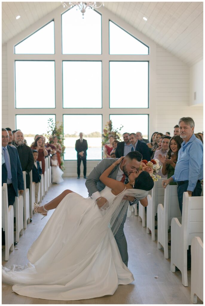 groom dipping bride for kiss at The Orchard Texas wedding