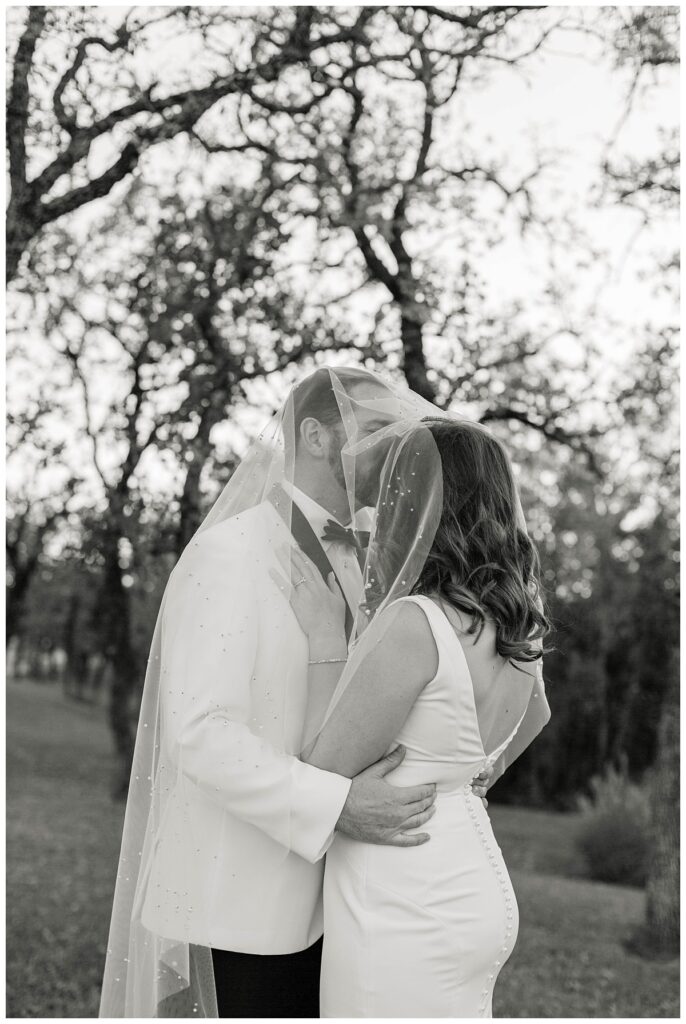 BW bride and groom kissing under veil