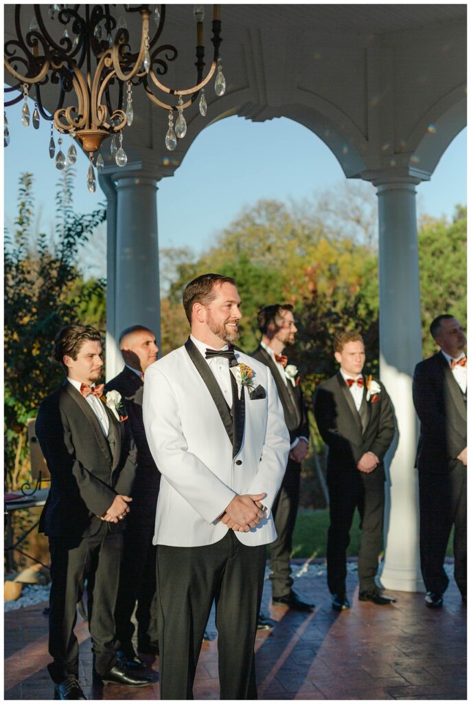 groom looking at bride walking down aisle