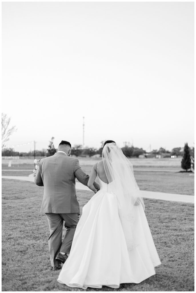 BW bride and groom walking away hand in hand