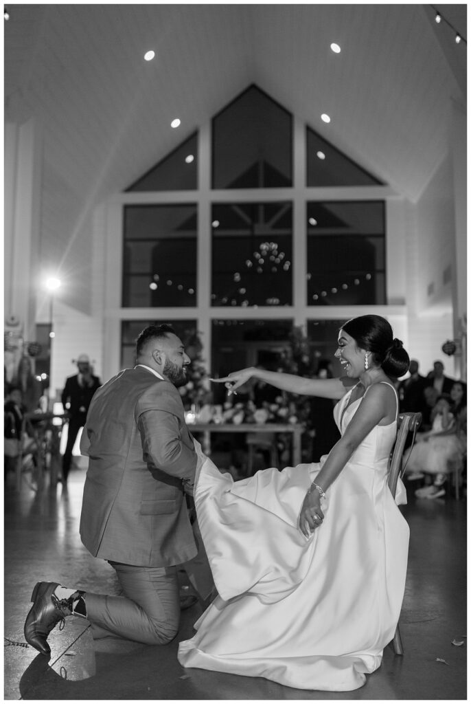 BW groom taking garter off bride at The Orchard Texas wedding venue